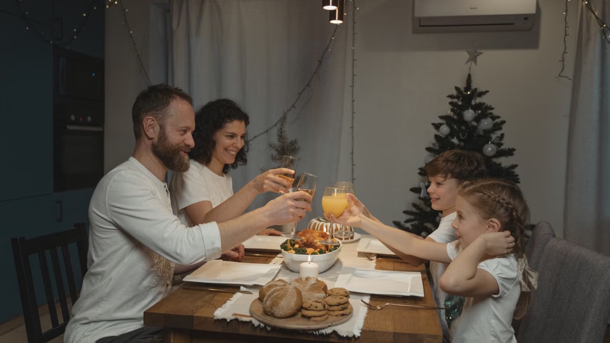 A joyful family toasting at a festive dinner table with festive decor indoors.